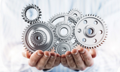 Engine mechanism in male ahnds as symbol for cooperation or team