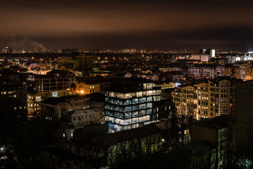 Fototapeta na wymiar cityscape with bright illumination in windows of buildings