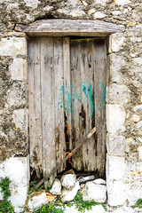 Rotted old wooden door of a stone house