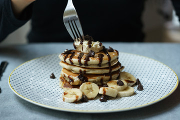 eating chocolate banana pancakes with fork