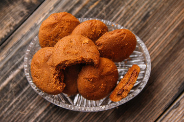 Cookies filled with chocolate cream in crystal bowl on old wooden table