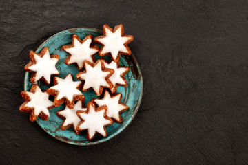 Obraz na płótnie Canvas Zimsterne, traditional German almond, chocolate and cinnamon star cookies, shot from the top on a black background with a place for text