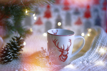 Obraz na płótnie Canvas Cup with a deer on the background of the lights of Christmas garland