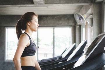 Fitness woman walking on treadmill in gym