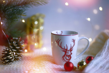 Obraz na płótnie Canvas Cup with a deer on the background of the lights of Christmas garland