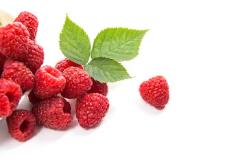 Small plate with ripe raspberries and green leaf isolated on white background.