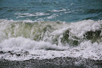 Wave foaming crashing on shore