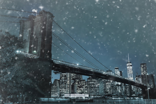 Toned photo of skyscrapers of Manhattan and Brooklyn bridge at snowy winter night