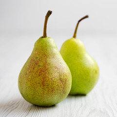 Fresh pears on a white wooden background, side view. Closeup.