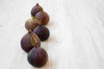Fresh figs on a white wooden surface, side view. Copy space.