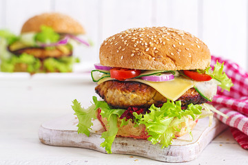 Tasty grilled homemade hamburger with burger chicken, tomato, cheese, cucumber, lettuce and...
