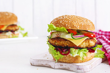 Tasty grilled homemade hamburger with burger chicken, tomato, cheese, cucumber, lettuce and beetroot. Sandwich. Lunch