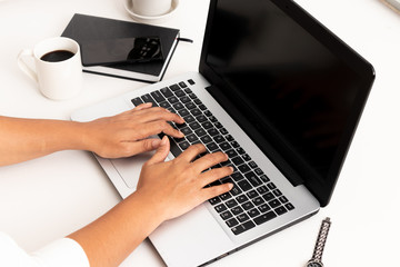 Business woman type on laptop computer on white office desk