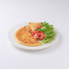 Plate of breakfast with omelette, toasts, tomato