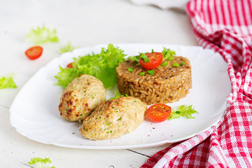 Homemade baked cutlets with rice on a table in a rustic style. Healthy food