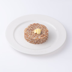 Cooked buckwheat porridge on plate. Isolated on a white background,