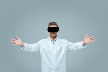 scientist in virtual reality headset holding something in open arms isolated on grey, artificial...