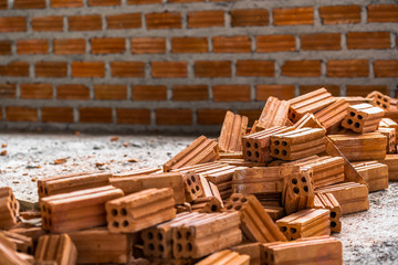 Stack of Brick preparing for mansonry over the photo blurred of Bricks wall background,