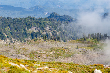 rocky soil overlook with clouds and view of forest and mountain sides