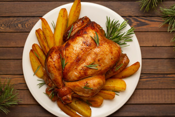 Roasted whole chicken with Christmas decoration. Wooden background.