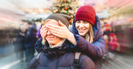 Fototapeta premium young female close his boyfriend eyes in the street on a winter holidays, surprise concept f