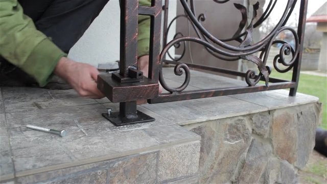 installation of forged railing,On the steps of the stone man sets railing forged