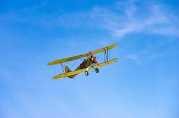 a green old plane flying in an air show