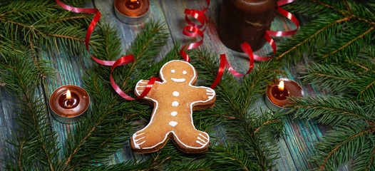 A gingerbread man with Christmas decorations and lots of fir branches.