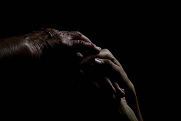 Silhouette of old wrinkled hands of an old grandmother granddaughter close-up