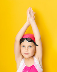 Portrait of a young girl in goggles and swimming cap.