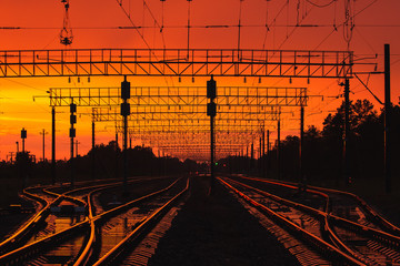 Naklejka na ściany i meble Dark Silhouettes Railway Infrastructure In Dramatic Sunset Backl