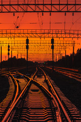 Fototapeta na wymiar Dark Silhouettes Railway Infrastructure In Dramatic Sunset Backl