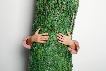 Little girl holding christmas tree in net - 238895252