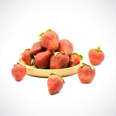 Sweet strawberry in wooden plate on a white background.