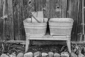 Time For New Appliances.  Old fashioned antique metal washtub and washboard in black and white in horizontal orientation.  - obrazy, fototapety, plakaty