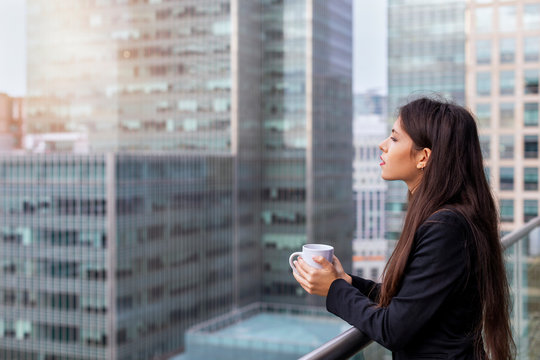 B&uuml;roangestellte bei der Kaffeepause auf dem Balkon vor modernen Wolenkratzern in der Stadt