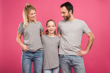 happy parents hugging with daughter, isolated on pink