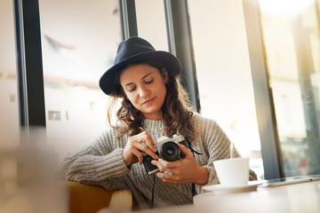 Beautiful brunette in modern cafe with vintage camera