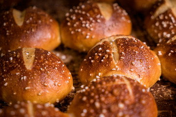 Frisch gebackene Laugenbrötchen auf dem Blech in Backstube - Variante 1