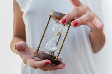 Woman's hands holding an hourglass