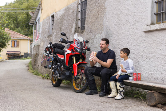 Father and son having a lunch break during a motorbike trip