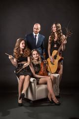 Man surrounded by beautiful girls musicians in evening lace dresses