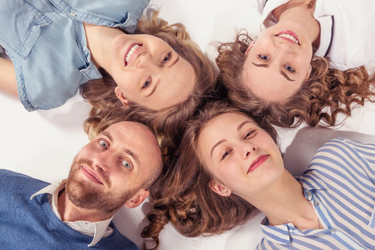 Portrait of friends lying on the floor heads to each other