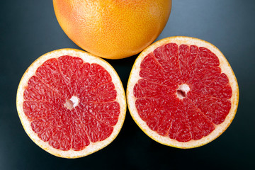 Fototapeta na wymiar Cut citrus fruit grapefruit on a dark background