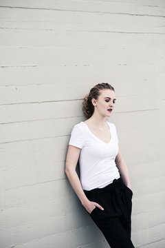 Portrait of cool young woman leaning against wall