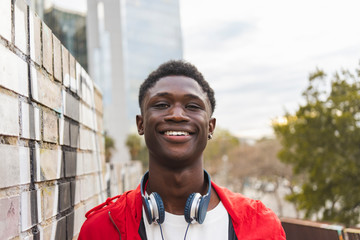 Young black man with headphones, smiling, portrait