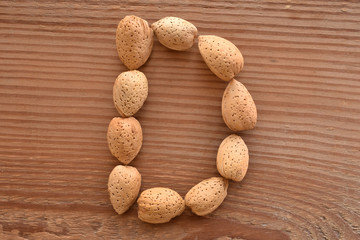 the letter D shaped with almonds on wood