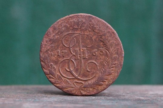 old brown russian copper coin on a gray table on a green background