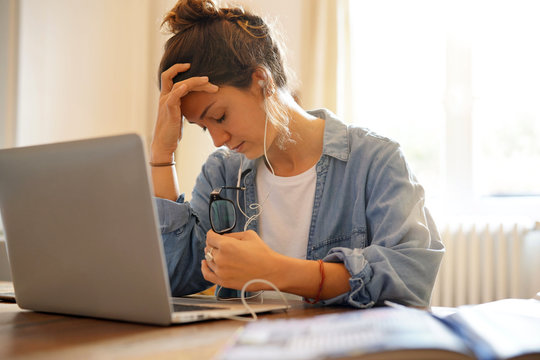 Stressed young woman working with laptop from home