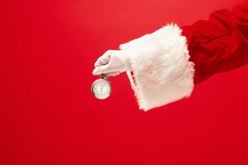 Santa holding an stopwatch on red background. The season, winter, holiday, celebration, gift concept